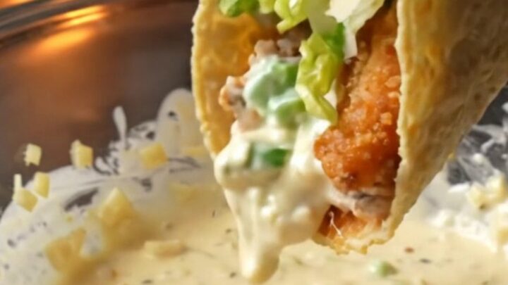 Crispy chicken Caesar smash tacos topped with romaine, parmesan, and Caesar dressing on a wooden board