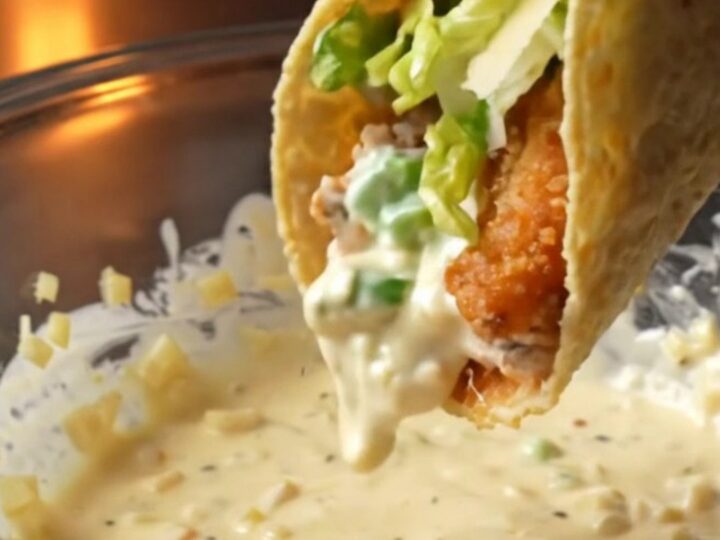 Crispy chicken Caesar smash tacos topped with romaine, parmesan, and Caesar dressing on a wooden board
