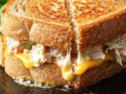 Creamy chicken melt on sourdough, sliced diagonally with melted cheese pulling apart.