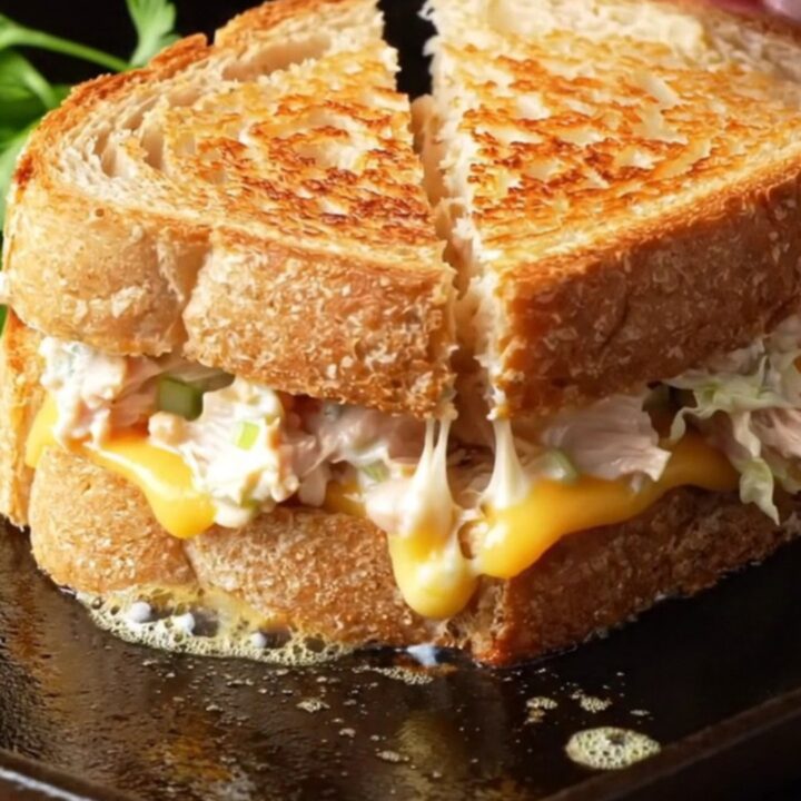 Creamy chicken melt on sourdough, sliced diagonally with melted cheese pulling apart.