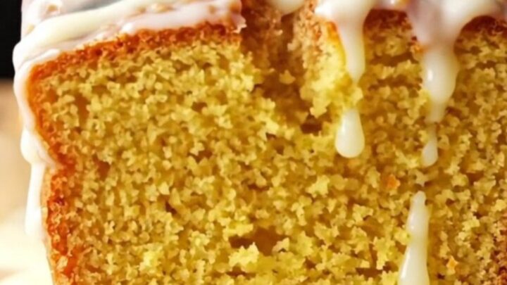 Whole lemon loaf cake with white glaze on a wire rack