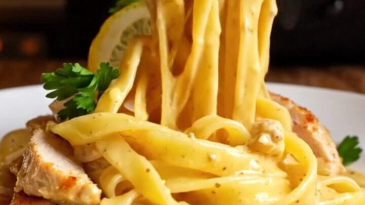 Golden seared chicken and fettuccine tossed in a creamy lemon garlic sauce, garnished with parsley and lemon wheels.