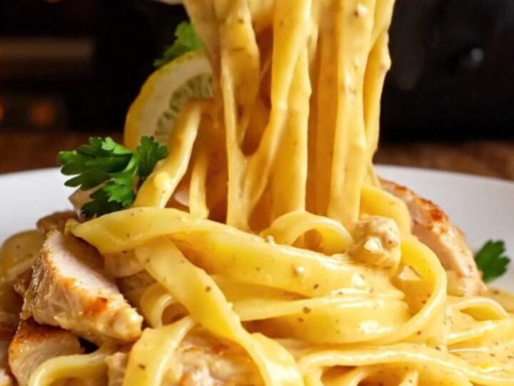 Golden seared chicken and fettuccine tossed in a creamy lemon garlic sauce, garnished with parsley and lemon wheels.