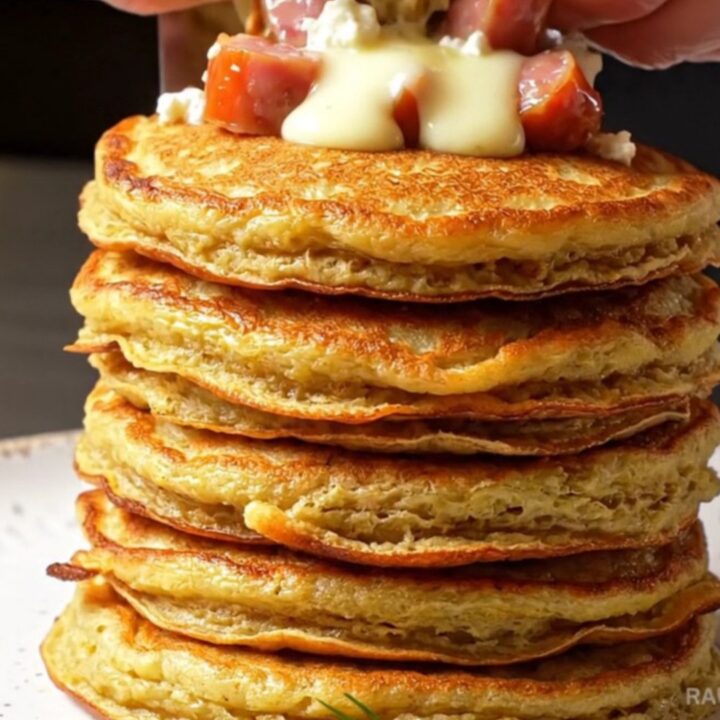 Stack of golden savory pancakes with feta and red peppers on a plate