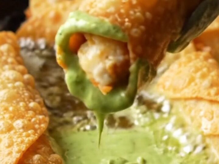 Crispy golden chicken taquitos with a bowl of green crema for dipping