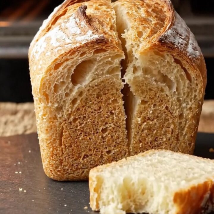 Artisan sourdough mini loaves with golden crackly crust on a wooden board