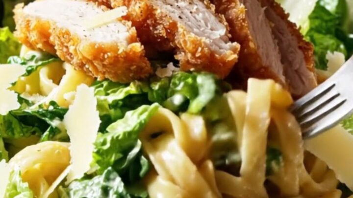 Crispy chicken strips on top of creamy Caesar pasta salad with shaved Parmesan