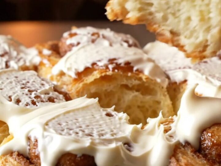 Golden pull-apart cinnamon rolls with cream cheese frosting in a baking dish