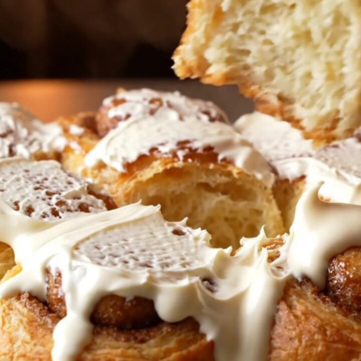 Golden pull-apart cinnamon rolls with cream cheese frosting in a baking dish