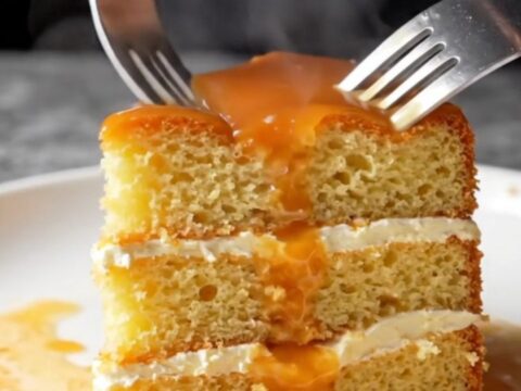 Golden caramel trileçe with creamy top and glossy amber caramel, slice lifted showing soaked layers