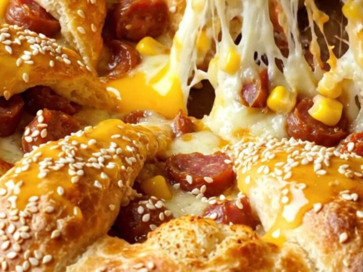 Golden crown pizza ring with melted cheese and sucuk on a baking sheet