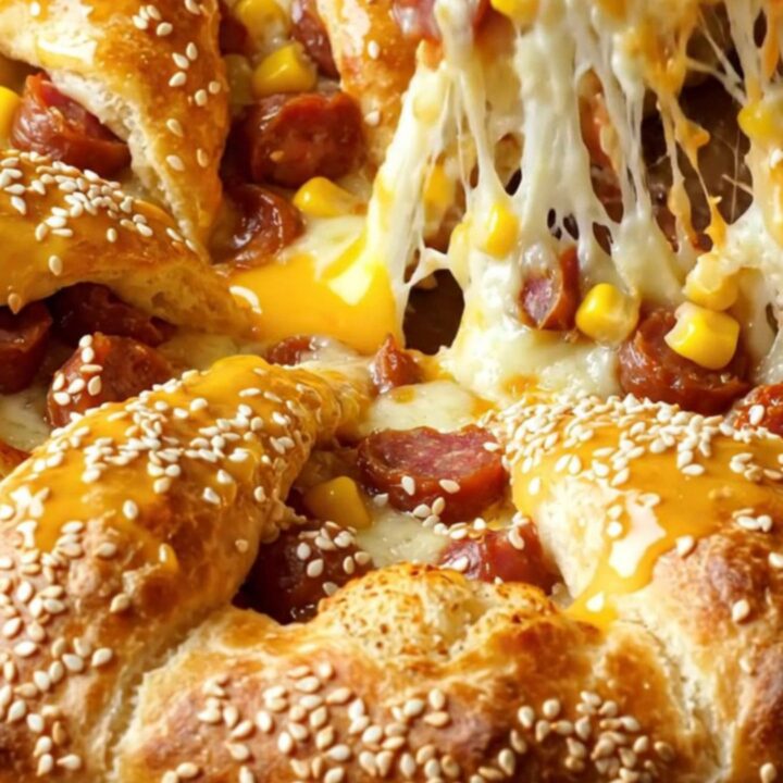 Golden crown pizza ring with melted cheese and sucuk on a baking sheet