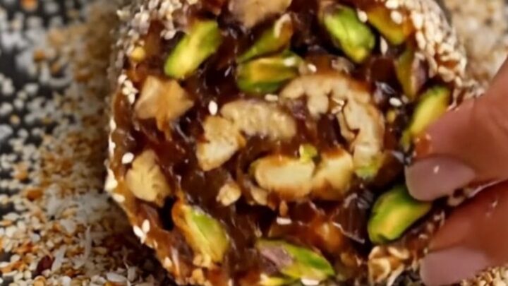 No-Bake Medjool Date and Nut Energy Roll sliced into thick medallions showing pistachios and walnuts.