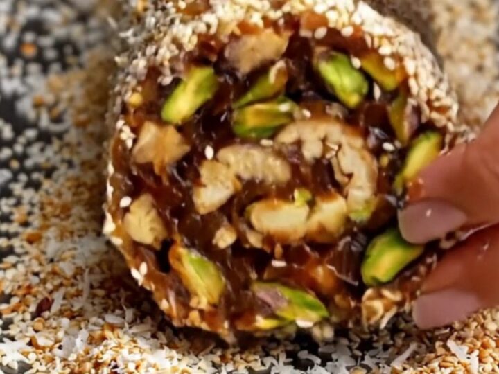 No-Bake Medjool Date and Nut Energy Roll sliced into thick medallions showing pistachios and walnuts.