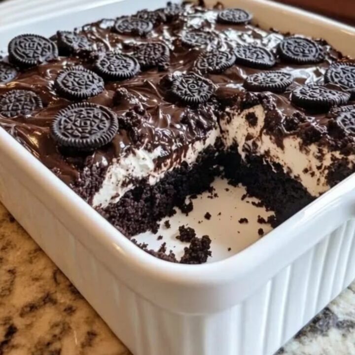 A warm slice of Oreo earthquake cake lifted with a spatula from a ceramic dish.