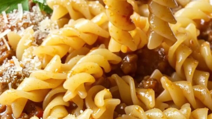 One-pan fusilli with meatball and vegetable ragù, topped with parsley and Parmesan, in a deep skillet.