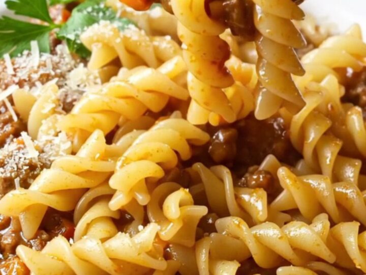 One-pan fusilli with meatball and vegetable ragù, topped with parsley and Parmesan, in a deep skillet.