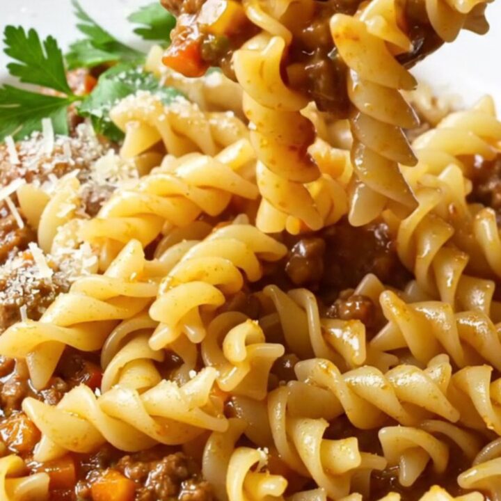 One-pan fusilli with meatball and vegetable ragù, topped with parsley and Parmesan, in a deep skillet.