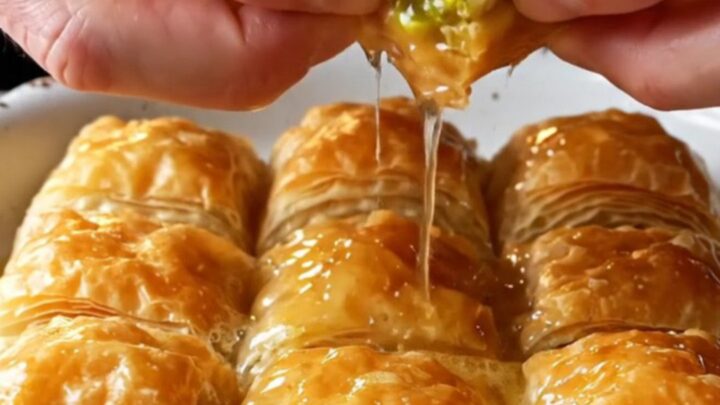 Golden Turkish Mussel Baklava drizzled with lemon syrup, showing flaky layers and pistachio filling.