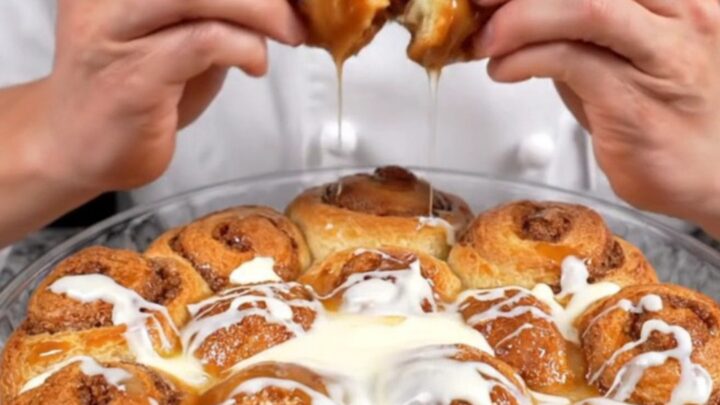 Pull-apart cinnamon monkey bread rolls with cream cheese glaze in a baking dish