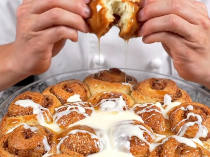 Pull-apart cinnamon monkey bread rolls with cream cheese glaze in a baking dish