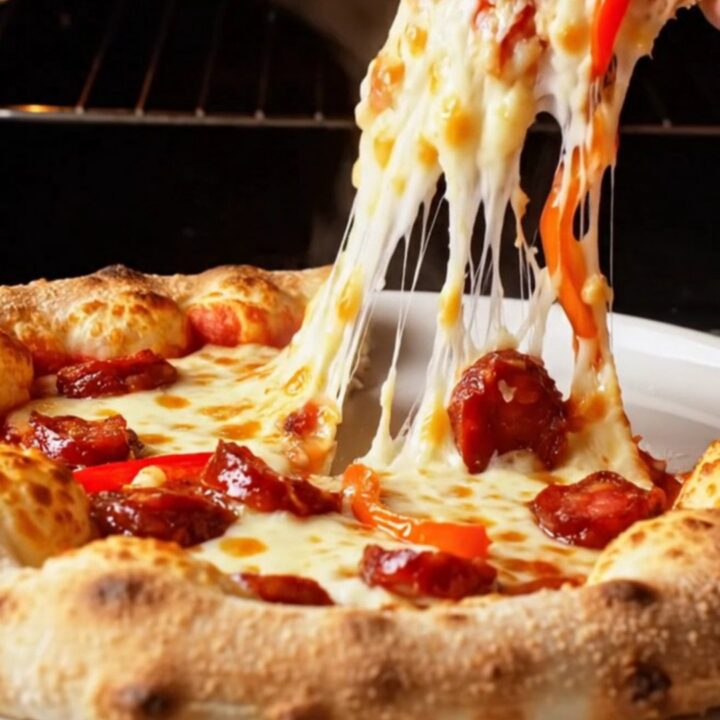 Golden stuffed ring pizza with melted cheese and sucuk on a parchment-lined baking sheet