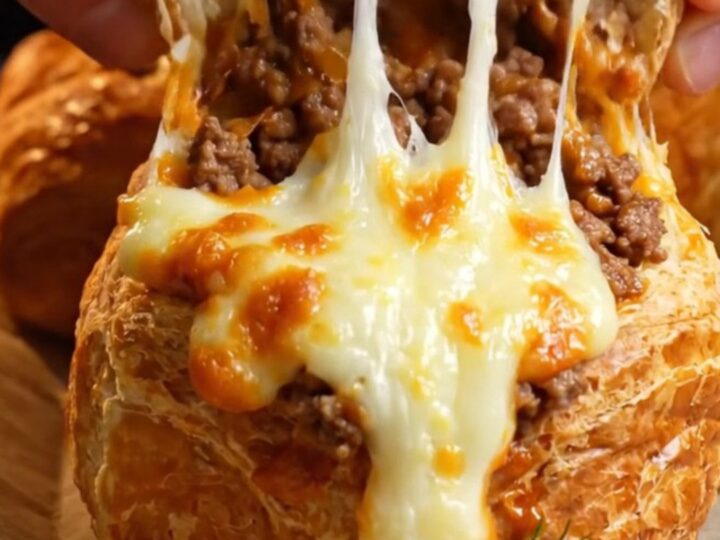 Golden clay-cup molded poğaça with a puffed crust and melted cheese peeking from the top