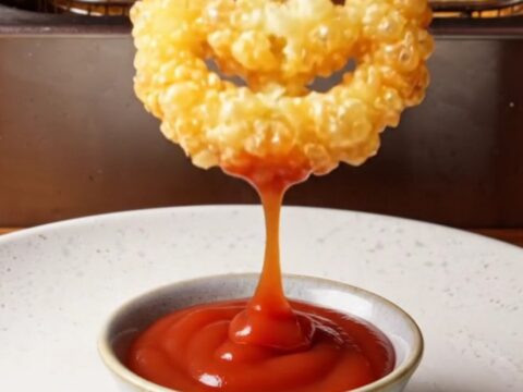 Golden crispy smiley face potato fries on a plate with ketchup