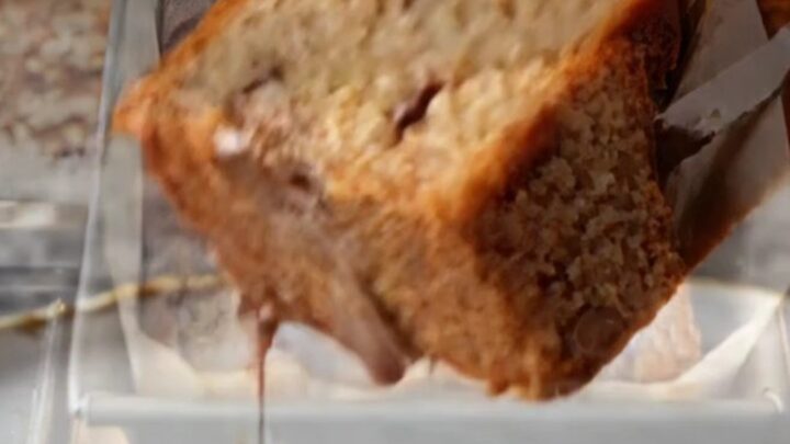 Sliced banana bread with melted chocolate chips on a wooden board