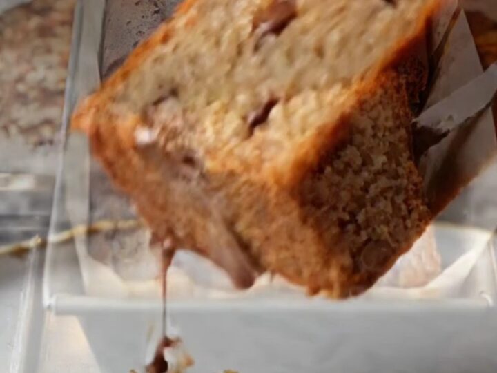 Sliced banana bread with melted chocolate chips on a wooden board