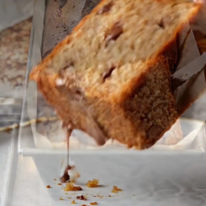 Sliced banana bread with melted chocolate chips on a wooden board