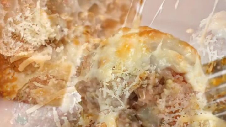 Golden cheese-crusted meatballs with peppers in a baking dish