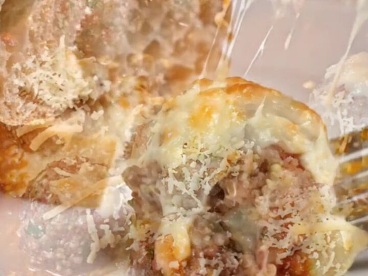 Golden cheese-crusted meatballs with peppers in a baking dish