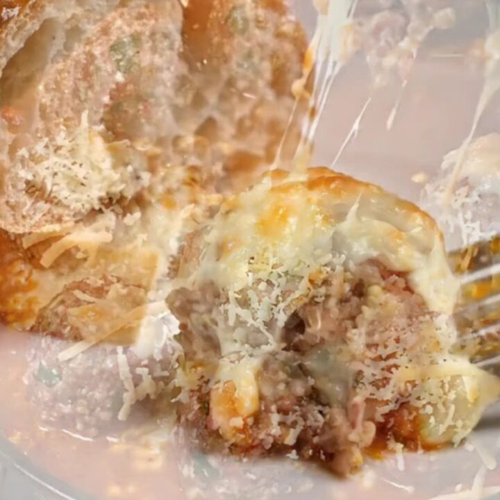 Golden cheese-crusted meatballs with peppers in a baking dish