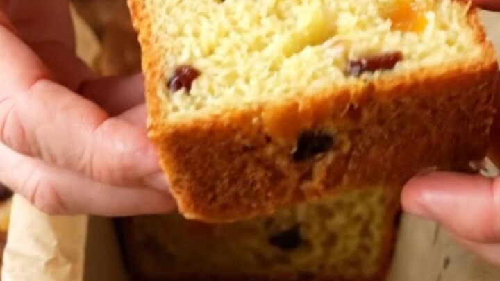 Golden whole lemon loaf with dried fruits, sliced to show moist crumb