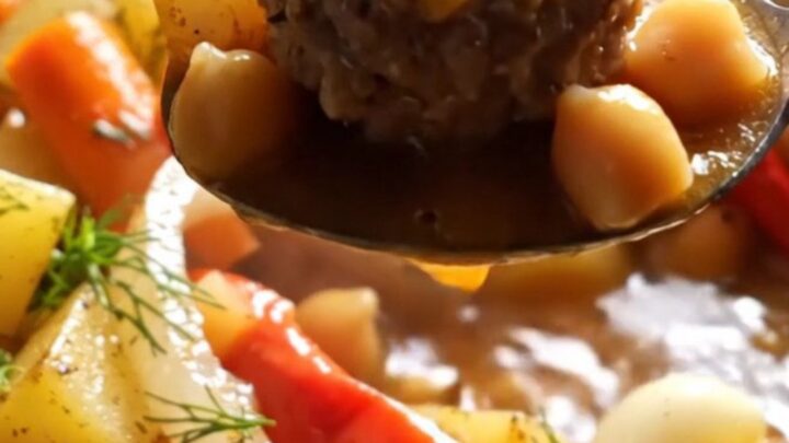 A bowl of Turkish meatball stew with meatballs, potatoes, chickpeas, and tomato broth