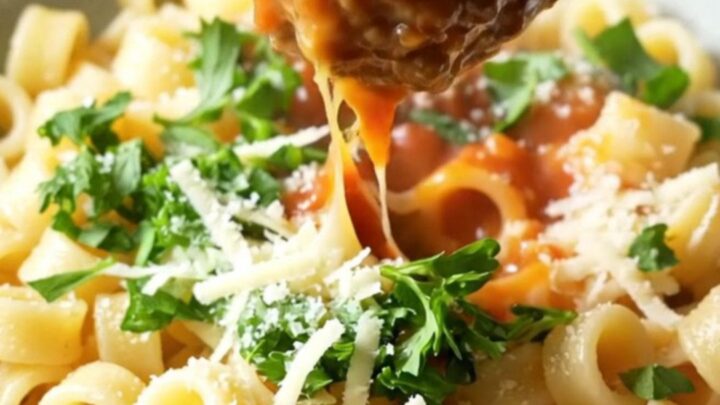 One-pan meatball ring pasta with whole tomatoes and melted mozzarella in a skillet
