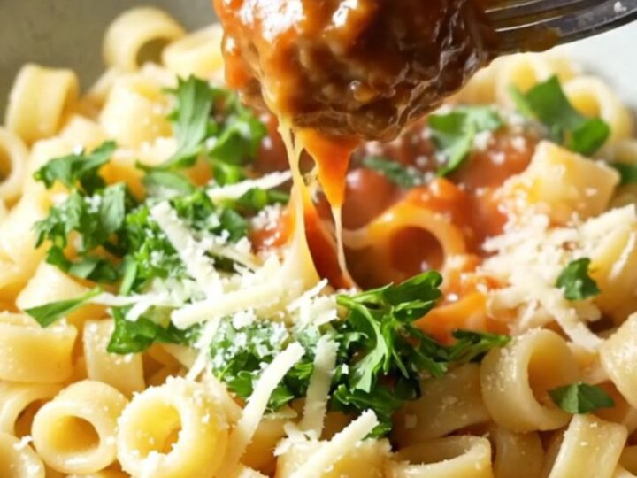 One-pan meatball ring pasta with whole tomatoes and melted mozzarella in a skillet