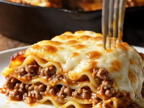 One-pan skillet lasagna with ground beef Bolognese, melted mozzarella, and parsley in a cast-iron skillet.