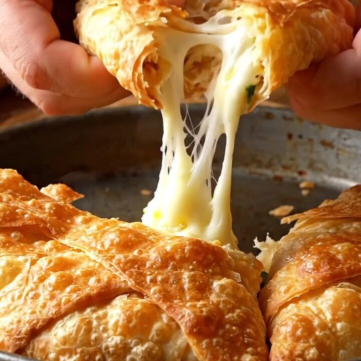 Hand-stretched cheese börek with golden flaky layers on a baking sheet.