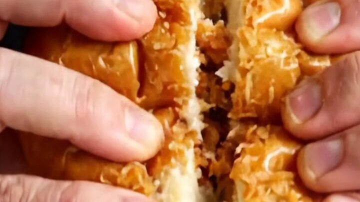 Crispy lemon chicken Caesar sandwich on a plate, cut in half showing layers