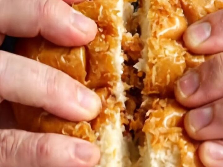 Crispy lemon chicken Caesar sandwich on a plate, cut in half showing layers
