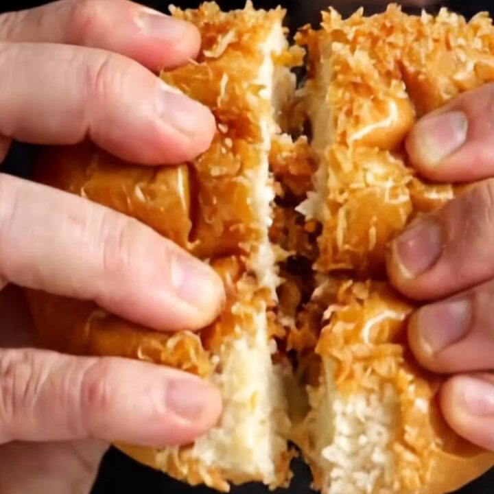 Crispy lemon chicken Caesar sandwich on a plate, cut in half showing layers