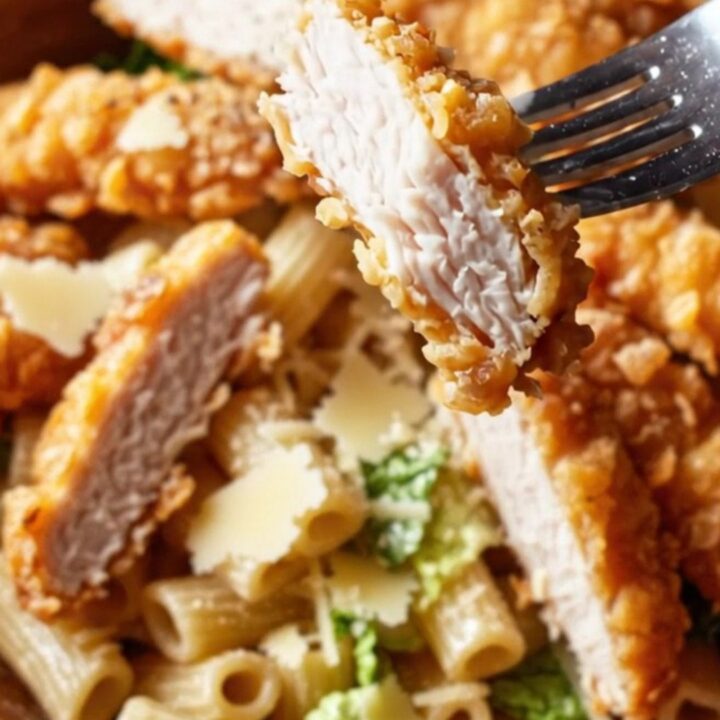Golden fried chicken strips on a bed of creamy Caesar pasta salad with Parmesan