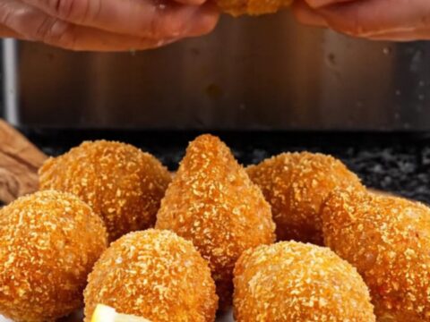 Golden fried içli köfte on a plate, one broken open to show the walnut-beef filling