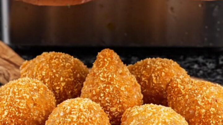 Golden fried içli köfte on a plate, one broken open to show the walnut-beef filling