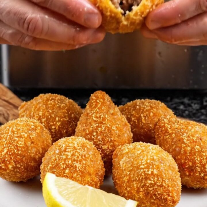 Golden fried içli köfte on a plate, one broken open to show the walnut-beef filling