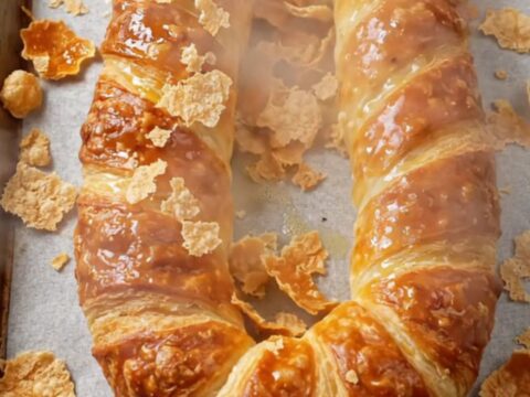 Golden horseshoe börek on parchment paper with a crisp, blistered crust