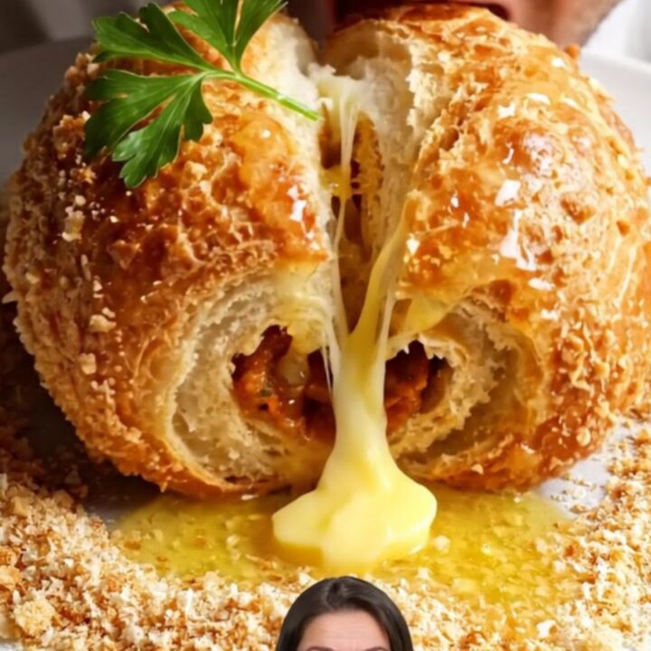 Golden crispy paçanga börek rolls on a parchment-lined tray, one snapped in half showing melted cheese and pastırma.