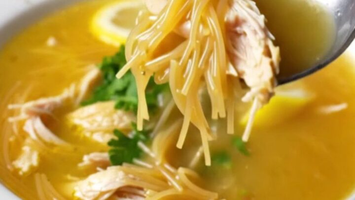A bowl of Turkish chicken vermicelli soup garnished with fresh parsley and lemon wedge